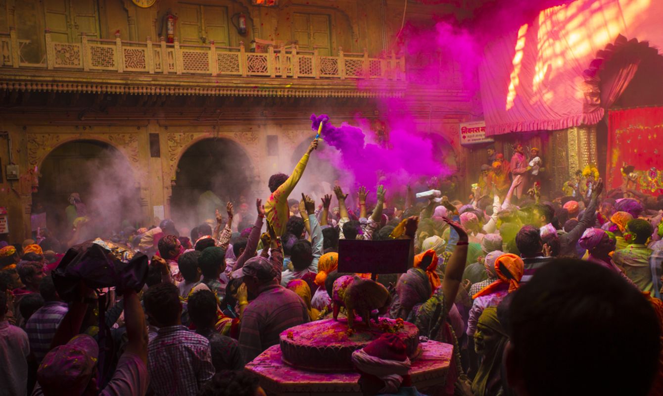 People throw colors to each other during the Holi celebration at Krishna temple