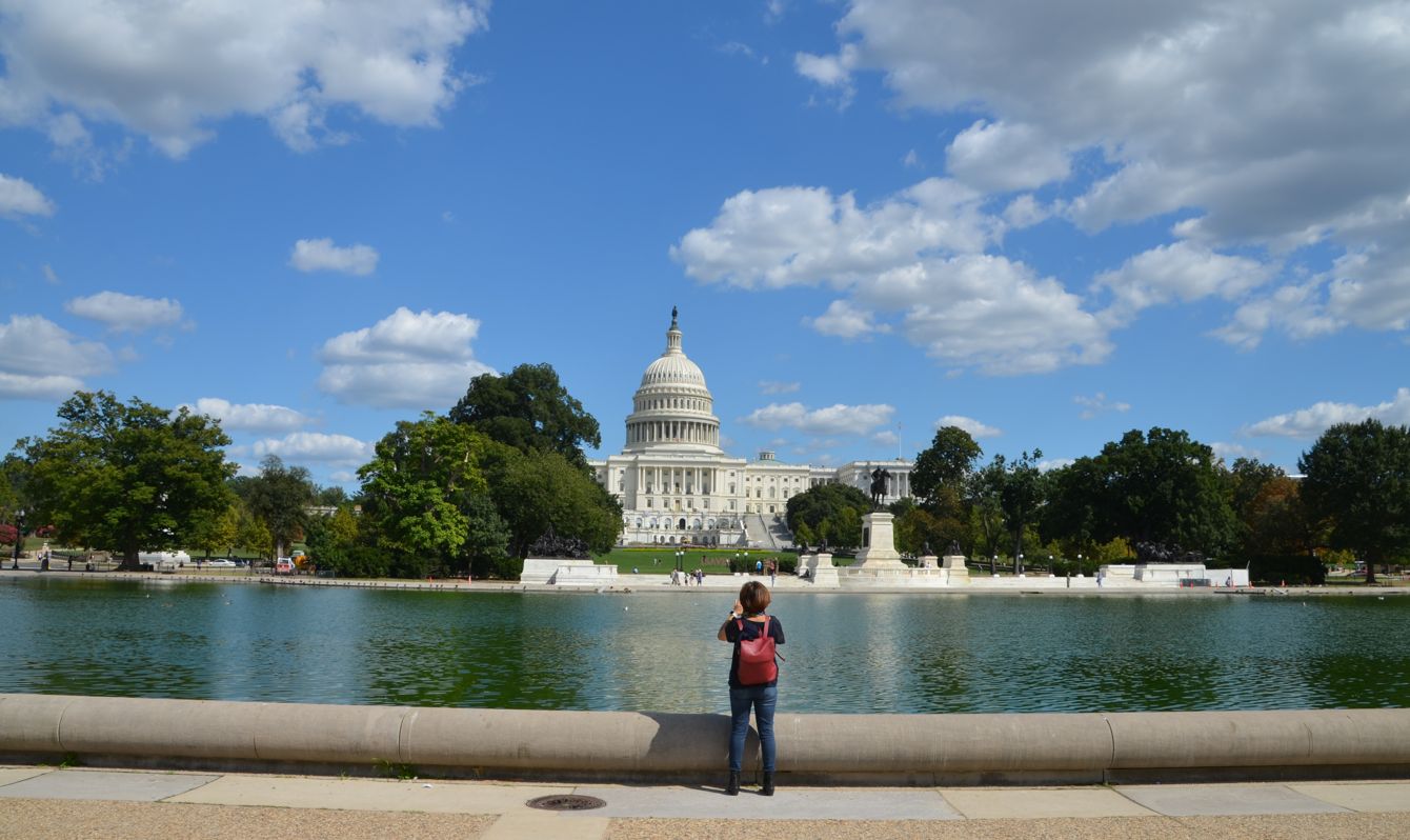 woman standing and taking photo of dome building