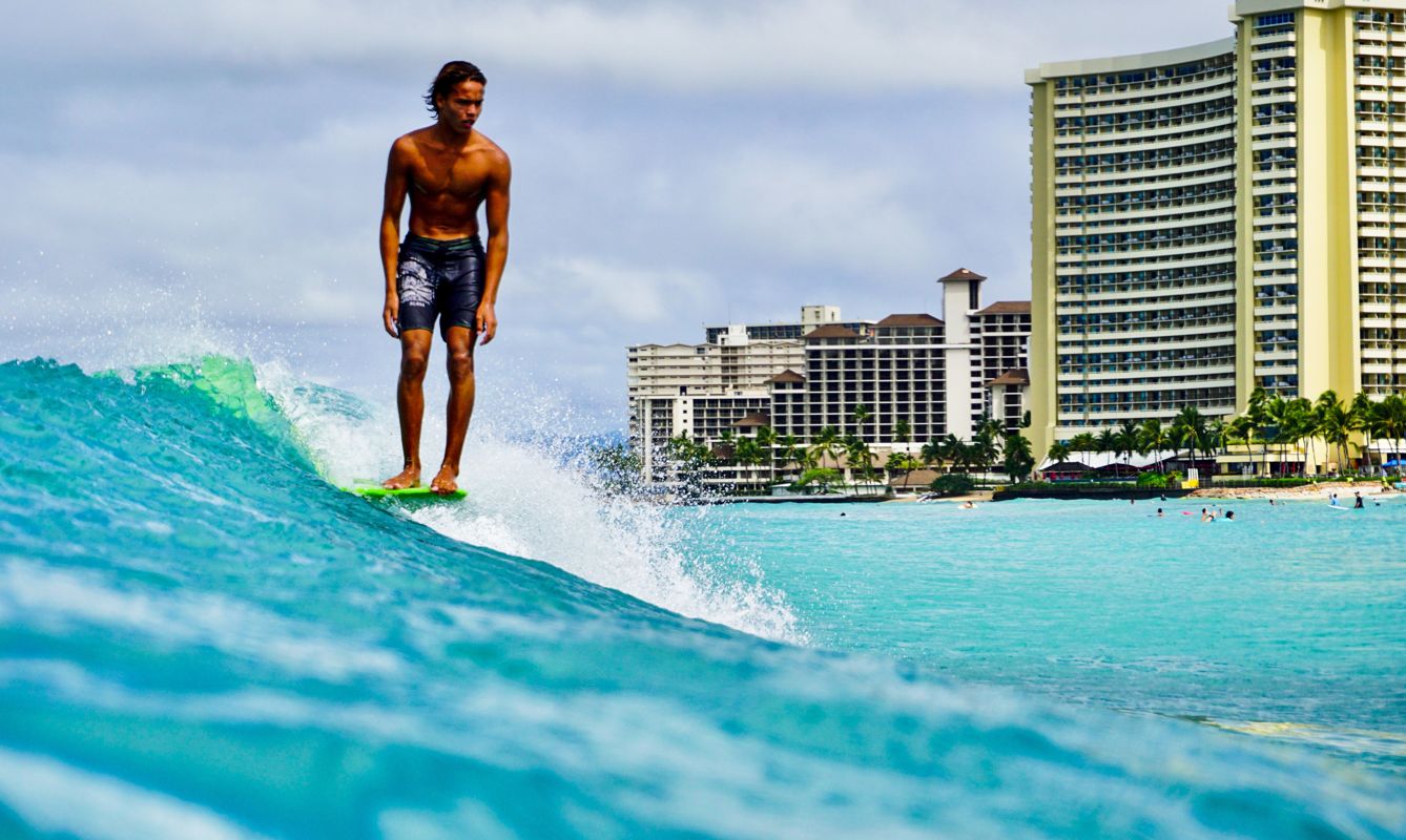 man in black shorts surfing on sea during daytime